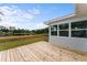 Large wooden deck with railings overlooks the lush green yard and beautiful lake at 37132 Turner Dr, Umatilla, FL 32784
