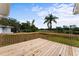 Large wooden deck with railings overlooks the lush green yard and beautiful lake at 37132 Turner Dr, Umatilla, FL 32784
