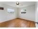 Inviting bedroom with gleaming hardwood floors, a ceiling fan, and natural light from the windows at 37132 Turner Dr, Umatilla, FL 32784
