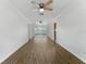 Spacious living room with stylish wood flooring, ceiling fans, and a sliding glass door to the patio at 37132 Turner Dr, Umatilla, FL 32784