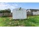 White shed offers practical backyard storage behind a full privacy fence at 37132 Turner Dr, Umatilla, FL 32784