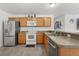 Efficient kitchen with stainless steel refrigerator, range, and dishwasher at 3756 Viscaya Ct, The Villages, FL 32163