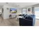 Spacious living room boasts modern furnishings, blue sofas, an entertainment center, and an adjacent dining area at 3756 Viscaya Ct, The Villages, FL 32163