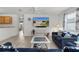 Living room featuring a blue couch, contemporary decor, and large screen television with views into the kitchen at 3756 Viscaya Ct, The Villages, FL 32163