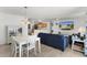Open-concept living space showcasing a white dining set, blue couches, and view into the kitchen at 3756 Viscaya Ct, The Villages, FL 32163