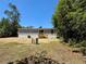 Home's exterior back view showing trees and planted grass at 43740 Sunset Dr, Paisley, FL 32767