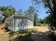 Exterior view of the home highlighting the backyard and treed lot at 43740 Sunset Dr, Paisley, FL 32767