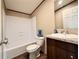 A bathroom with a shower and bath combination, featuring wood-look floors and granite vanity at 43740 Sunset Dr, Paisley, FL 32767