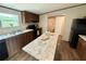 A kitchen with wood cabinets, black appliances and a large island with light countertops at 43740 Sunset Dr, Paisley, FL 32767