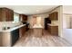 Spacious kitchen features wood cabinetry, an island, modern appliances and wood-look flooring at 43740 Sunset Dr, Paisley, FL 32767