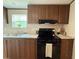 View of kitchen with dark wood cabinets, stainless steel sink, black range, and granite countertops at 43740 Sunset Dr, Paisley, FL 32767