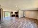 Open-concept living room and kitchen with wood-look flooring and sliding glass doors leading to the outside at 43740 Sunset Dr, Paisley, FL 32767