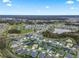 Sprawling community view showcasing residences, green spaces, and a serene pond under a bright sky at 4406 Creighton Loop, The Villages, FL 32163