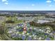 Panoramic aerial view of a residential community with houses, golf course, and a pond at 4406 Creighton Loop, The Villages, FL 32163
