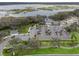 Aerial view shows a community clubhouse and parking, with a lake in the distance at 4406 Creighton Loop, The Villages, FL 32163