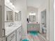 Bathroom featuring dual sinks, gray cabinets, and decorative blue accents at 4406 Creighton Loop, The Villages, FL 32163