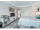 Bright bedroom featuring tray ceilings, wood-look floors, and an entertainment center at 4406 Creighton Loop, The Villages, FL 32163