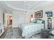 Comfortable bedroom with coastal-themed decor, tray ceilings, and wood-look floors at 4406 Creighton Loop, The Villages, FL 32163