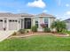 Well-manicured front yard with lush green grass, mulch flower beds, and attractive landscaping at 4406 Creighton Loop, The Villages, FL 32163