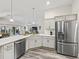 Open-concept kitchen with a modern stainless steel refrigerator and a breakfast bar area at 4406 Creighton Loop, The Villages, FL 32163