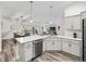 Bright kitchen featuring sleek countertops, stainless steel dishwasher, and an open view to the living area at 4406 Creighton Loop, The Villages, FL 32163