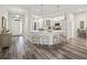Open-concept kitchen with white countertops, a breakfast bar with stools, and wood-look flooring at 4406 Creighton Loop, The Villages, FL 32163