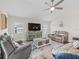 Bright and open living room with comfortable seating, entertainment center and lots of light at 4406 Creighton Loop, The Villages, FL 32163
