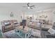 Inviting living room with plush seating, modern ceiling fan, and seamless flow into the dining and kitchen areas at 4406 Creighton Loop, The Villages, FL 32163