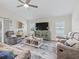 Comfortable living room with a vaulted ceiling, fan and large windows; entertainment center at 4406 Creighton Loop, The Villages, FL 32163
