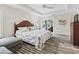 Sunlit main bedroom offers wood floors, tray ceiling, and access to the outdoor living space at 4406 Creighton Loop, The Villages, FL 32163