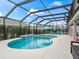 Relax in this screened pool with a charming waterfall feature and lush landscaping for privacy at 4406 Creighton Loop, The Villages, FL 32163