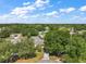 Aerial view of the home in a neighborhood setting with mature trees and lush landscaping at 4553 Belle Grv, Leesburg, FL 34748