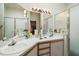 Bright bathroom featuring a double sink vanity, large mirror, and a walk-in shower with glass doors at 4553 Belle Grv, Leesburg, FL 34748