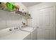 Functional laundry room featuring modern washer and dryer, complemented by ample shelving storage at 4553 Belle Grv, Leesburg, FL 34748