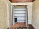 Spacious hallway closet with shelving and a folding ladder for ample storage at 500 Newell Hill Rd # D, Leesburg, FL 34748