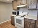 Cozy kitchen with essential appliances, ample counter space, and wood-look cabinets at 500 Newell Hill Rd # D, Leesburg, FL 34748