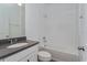 This bathroom features a tub with tile surround, modern vanity, and neutral color palette at 5031 Abigail Dr, Lake Wales, FL 33859