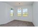 Bright dining area with wood-look tile floors and three windows offering scenic views at 5031 Abigail Dr, Lake Wales, FL 33859