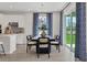 Bright dining room features stylish chandelier, sliding glass doors, and decoratively patterned curtains at 5039 Abigail Dr, Lake Wales, FL 33859