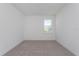 Carpeted bedroom with base molding, an electrical outlet and a window overlooking the yard at 5043 Abigail Dr, Lake Wales, FL 33859