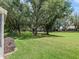 Spacious backyard featuring mature trees and lush green lawn at 511 Chula Vista Ave, The Villages, FL 32159