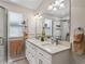 Bright bathroom featuring double sinks, white cabinets, and a glass-enclosed shower at 511 Chula Vista Ave, The Villages, FL 32159
