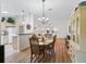 Open dining room and living room with hardwood floors, chandelier, and lots of natural light at 511 Chula Vista Ave, The Villages, FL 32159