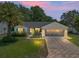 Charming single-story home featuring a well-manicured lawn, mature palm tree, and a patterned driveway at 511 Chula Vista Ave, The Villages, FL 32159