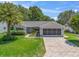 Charming single-story home featuring a well-maintained lawn and a screened two-car garage at 511 Chula Vista Ave, The Villages, FL 32159