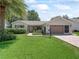 Well-kept single-story home with a manicured lawn, a two-car garage, and tidy landscaping at 511 Chula Vista Ave, The Villages, FL 32159