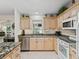 Bright kitchen featuring stainless steel appliances, granite counters, and white cabinets at 511 Chula Vista Ave, The Villages, FL 32159