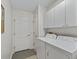 Functional laundry room with a washer, dryer, storage cabinets, and access to the garage at 511 Chula Vista Ave, The Villages, FL 32159