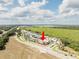 Aerial view of a single Gathering home and community surrounded by greenery, under a cloudy sky at 5325 Zisa Ct, The Villages, FL 32163