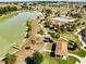 Aerial view of community with a dock, lake and community pool at 5325 Zisa Ct, The Villages, FL 32163